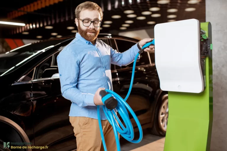 Un homme utilisé une borne de recharge pour voiture électrique.