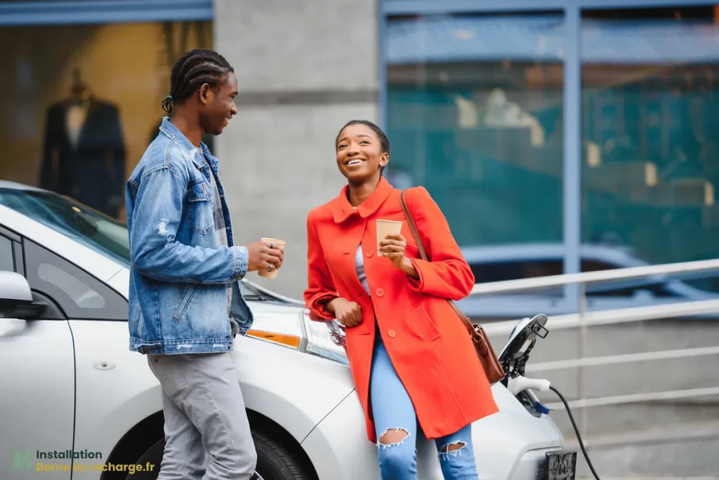 Un couple discute pendant que leur voiture électrique se recharge.